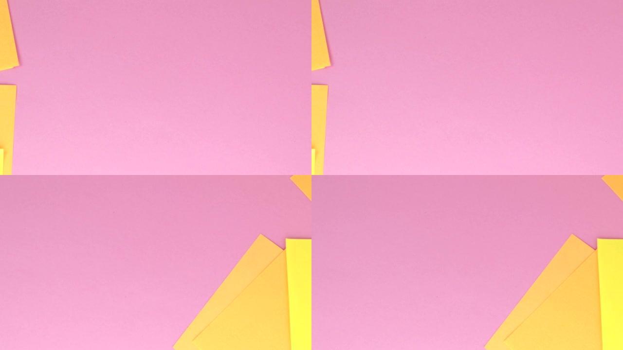 4到视频，方形的黄色便条纸在粉红色的纸背景上飞离风，俯视图