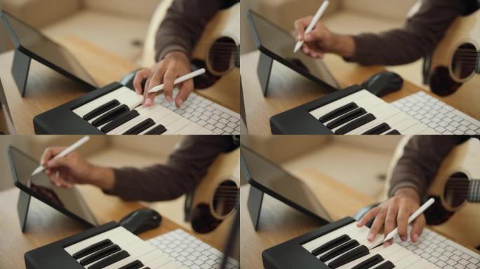 特写手专业歌曲作者弹吉他和钢琴键盘与平板电脑混合和掌握音乐。男在录音室用音响设备创作歌曲。音乐家概念