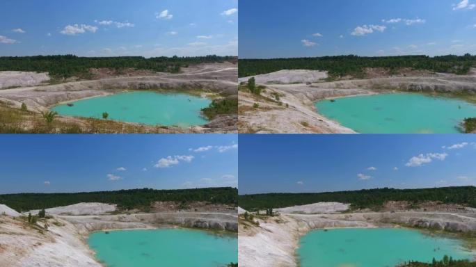 高岭土采石场美丽的风景。充满水的深粘土矿。碧蓝的天空在池塘里反射。