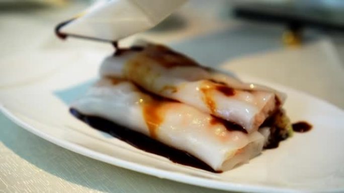 在点心中餐粤菜餐厅将甜酱油倒在张fun蒸米粉卷上