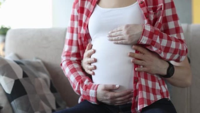 男人和女人在怀孕的最后一个月抚摸着肚子