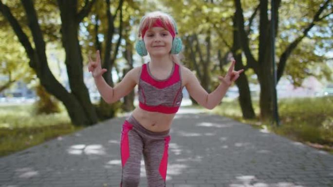 运动跑步者女童训练锻炼耳机听音乐对着镜头跳舞玩得开心