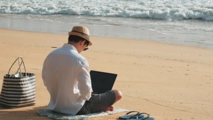 商人，自由职业者，在现代科技的热带海滩上用笔记本电脑工作。假期的概念。