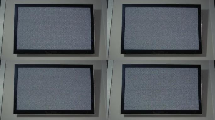 现代电视挂在家里的墙上，屏幕上有灰色噪音