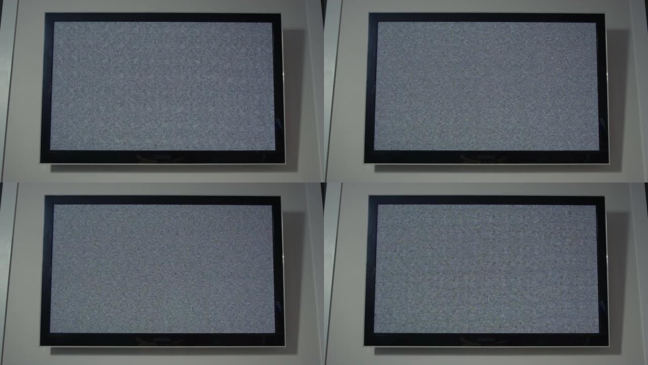 现代电视挂在家里的墙上，屏幕上有灰色噪音
