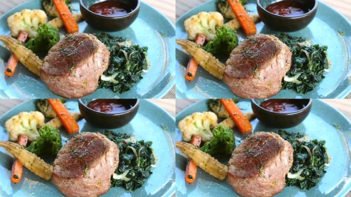 豪华餐厅的蓝盘烤里脊肉牛排。在户外咖啡馆将牛肉与蔬菜，绿色菠菜和酱汁一起烤成晚餐。健康的酮饮食。