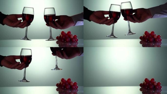 红酒齐打，干杯概念。以慢动作拍摄。两个人戴眼镜。餐桌上的新鲜葡萄