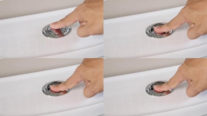 用手指按下马桶上的按钮的特写镜头，以清洁浴室中的污水，腹泻，食物中毒。