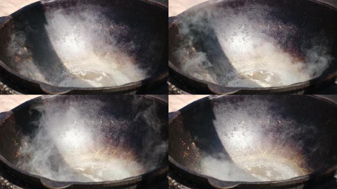 火上油的大锅。在Karahi中在燃木粘土烤箱中加热油。在外面做饭的壁炉。罗马尼亚大锅火上浇油。