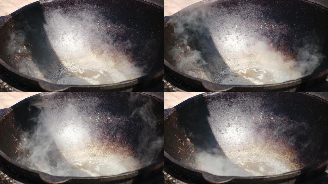 火上油的大锅。在Karahi中在燃木粘土烤箱中加热油。在外面做饭的壁炉。罗马尼亚大锅火上浇油。