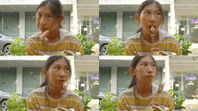 亚洲女孩在泰国华欣的露天街头美食餐厅与家人共进早餐。