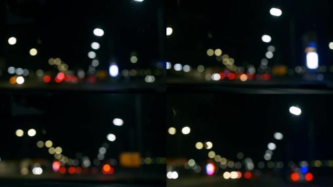 夜间道路灯光聚焦。美丽的bokeh在夜间高速公路的城市道路上。交通中的汽车尾灯和迎面而来的汽车的模糊