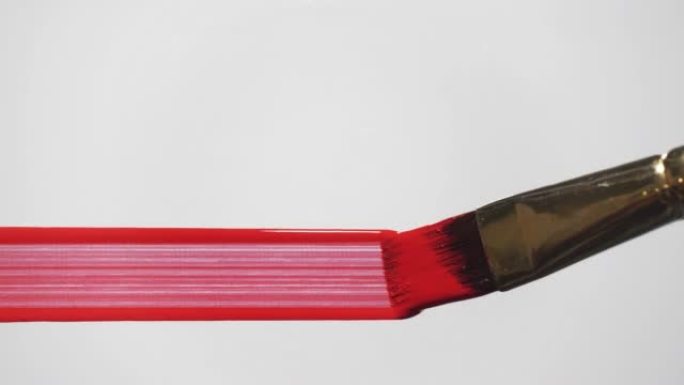 艺术家在白色背景上用画笔画红线。