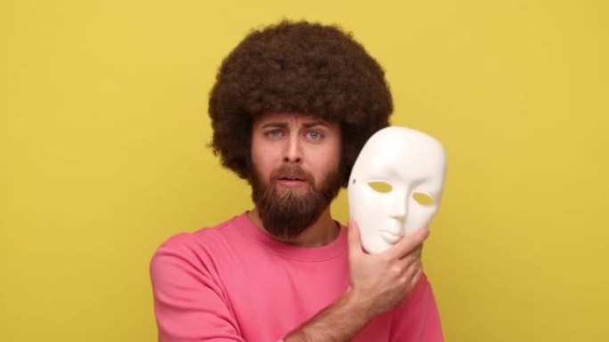 Bearde hipster man脱下面具，表现出不同的情感，口是心非，虚伪。