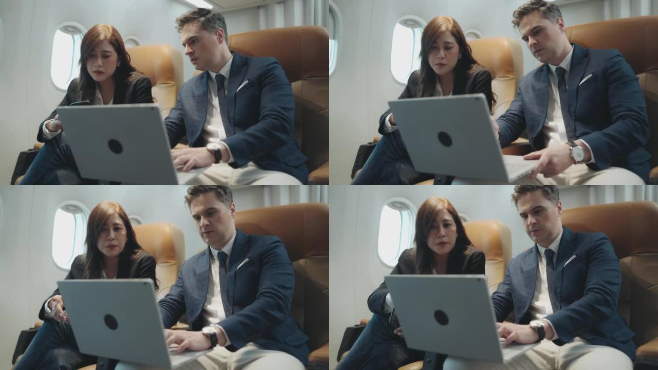 乘飞机旅行时在笔记本电脑上工作的商人和女商人。