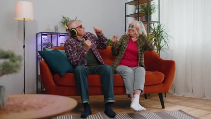 快乐的高级祖父母男人女人听音乐跳舞迪斯科鬼混在家里玩