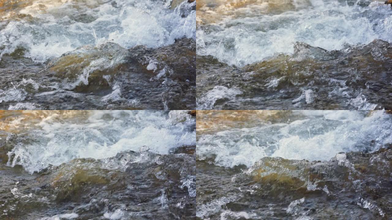 晴天，快速的春江流过岩石，形成白色的水波，特写细节-抽象的自然背景