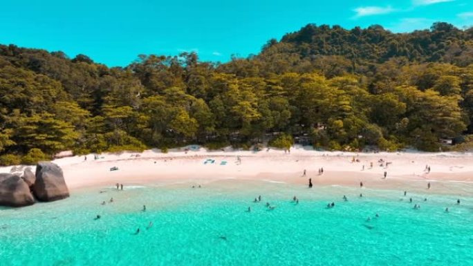 游客或旅行者正在海滩上沐浴在阳光下，游泳，阅读和玩游戏。泰国攀牙省四岛 (Miang island)