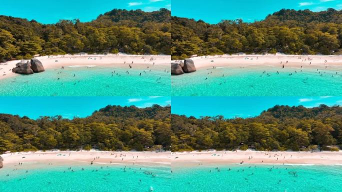 游客或旅行者正在海滩上沐浴在阳光下，游泳，阅读和玩游戏。泰国攀牙省四岛 (Miang island)