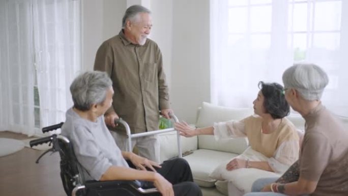 团体亚洲老年人患有某些疾病的朋友一起坐在家里的客厅里，一起享受着交谈。