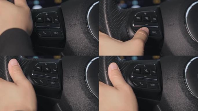 驾驶员的手正在按下汽车方向盘上的应答按钮。免提通话。运输和技术的概念