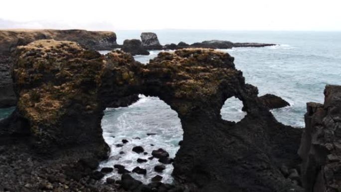 在冰岛Arnarstapi崎rough的大西洋沿岸，由火山玄武岩形成的著名天然拱门Gatklettu
