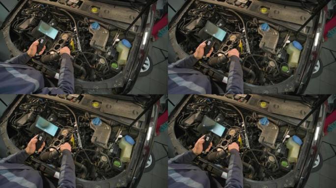 汽车修理工的手用带有旋转摄像头和手机的技术内窥镜检查车辆发动机。修理发动机头和气门。