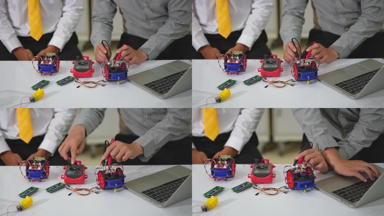 亚洲学生和老师使用电子仪表和笔记本电脑在科学课中构建自主自驱动机器人汽车的原型