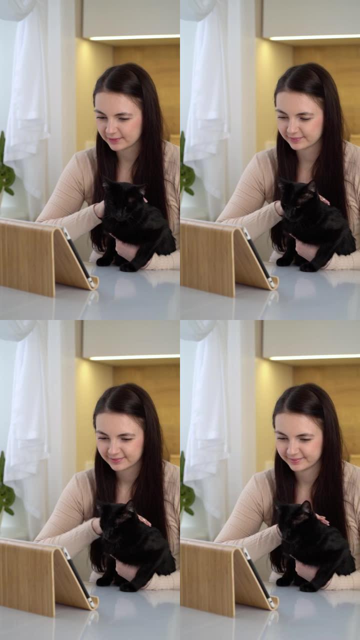 快乐的女人使用数字平板电脑与猫。
