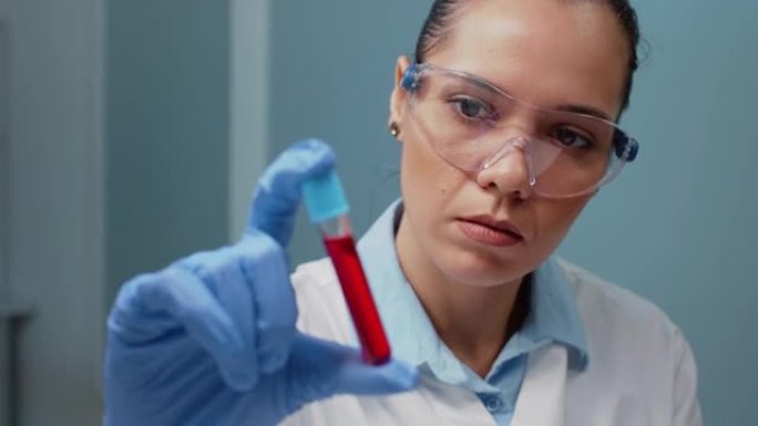 实验室科学家拿着带有血液样本的真空容器