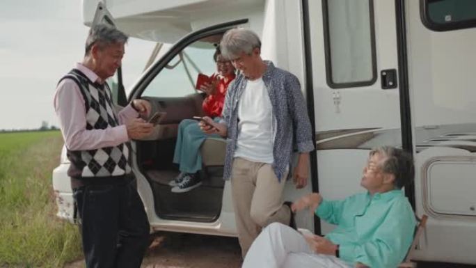 露营车汽车之家旁的智能手机上的亚洲华人活跃高级阅读