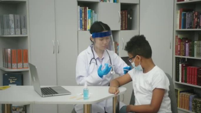 亚洲护士为戴着眼镜和口罩的拉丁男孩制造疫苗