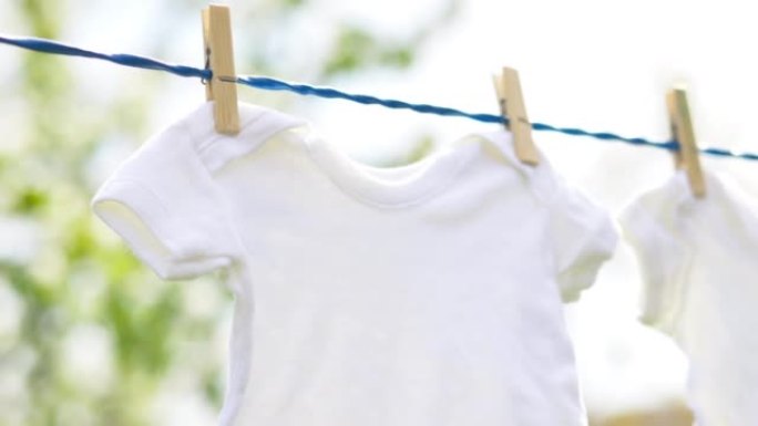 春日户外挂在绳子上的白色婴儿衣服。