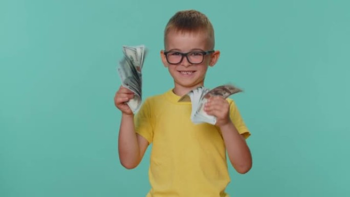 蹒跚学步的儿童男孩拿着现金美元钞票的粉丝庆祝舞蹈彩票游戏赢家