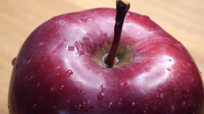 红色酋长品种的成熟大苹果。苹果皮上的水滴。带水果的宏视频。美味的苹果。