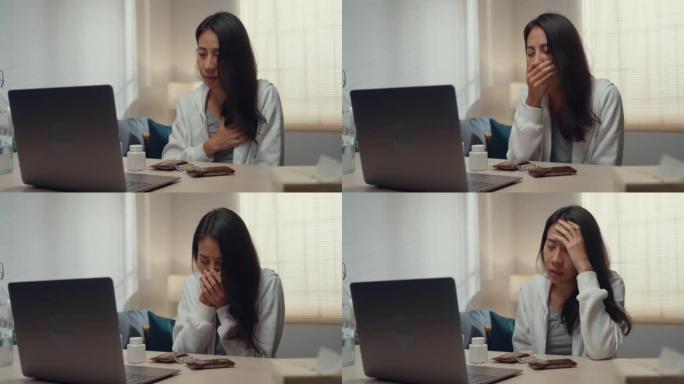 生病的年轻亚洲妇女使用笔记本电脑在家里的客厅与医生交谈。