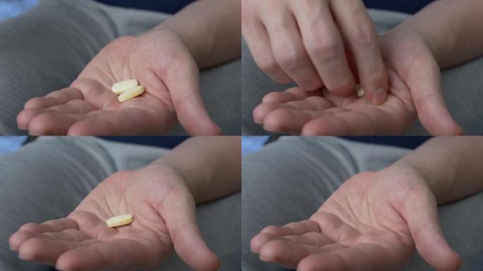 两粒黄色药片倒在手心上，用于治疗严重疾病。病人服用医生为治疗传染病开的药。