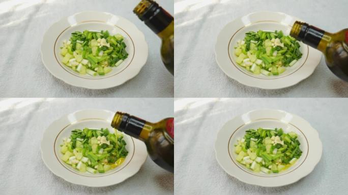 葱沙拉的俯视图。一只手用叉子搅动桌子上的绿色沙拉