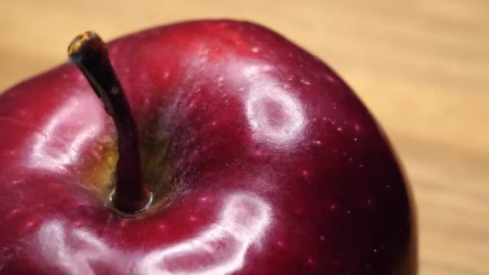 一个大红苹果旋转，特写视频。苹果皮上的亮点。红色首席品种的苹果，4k。