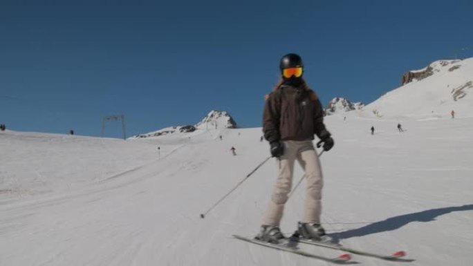 穿着反光眼镜的女人滑雪下坡