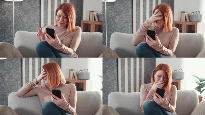 成年妇女坐在沙发上拿着手机阅读不愉快的消息坏短信感到沮丧开始哭泣。