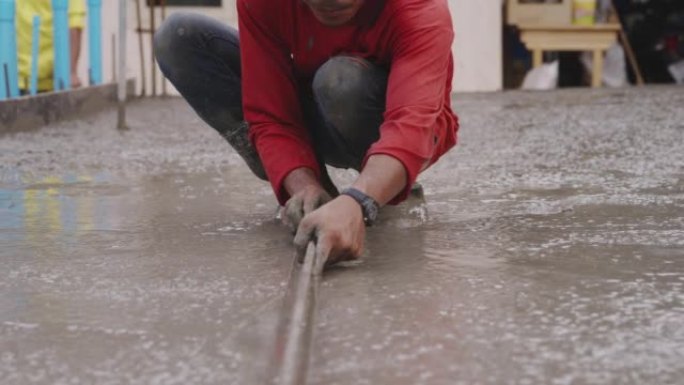 建筑工人在工地上建造找平层水泥地板。