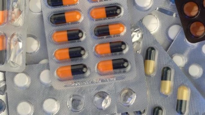 随着药丸旋转关闭。药丸和毒品。带有泡罩包装的药物，药丸和药片。医用药丸包裹的特写视图。