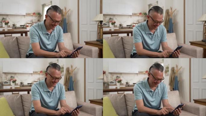 亚洲日本退休男子在家中客厅独自用手机阅读网络新闻的肖像