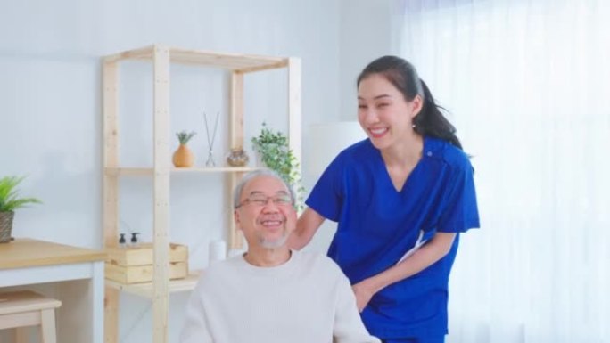 亚洲护理员护士的肖像坐在轮椅上照顾高级男性。有吸引力的专业护理妇女支持老年成熟的祖父在养老院护理和微