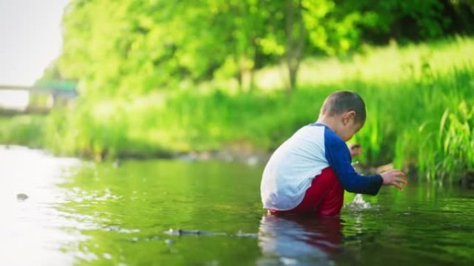 小男孩喜欢在大自然的小河里戏水