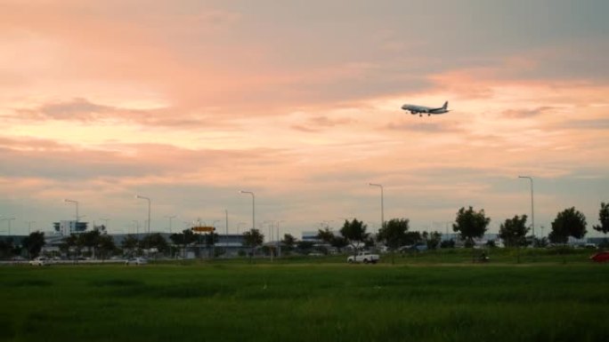2022年7月11日，曼谷，飞机在素万那普国际机场跑道和机场旁边的公路上起降，夜间汽车运送乘客。在泰