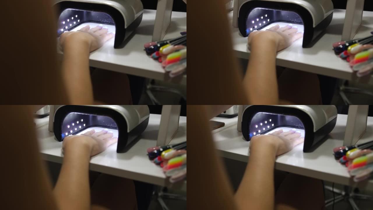 女性客户用紫外线灯特写4k电影在指甲上干燥凝胶抛光剂