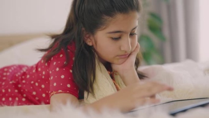 印度女孩在床上玩数字平板电脑