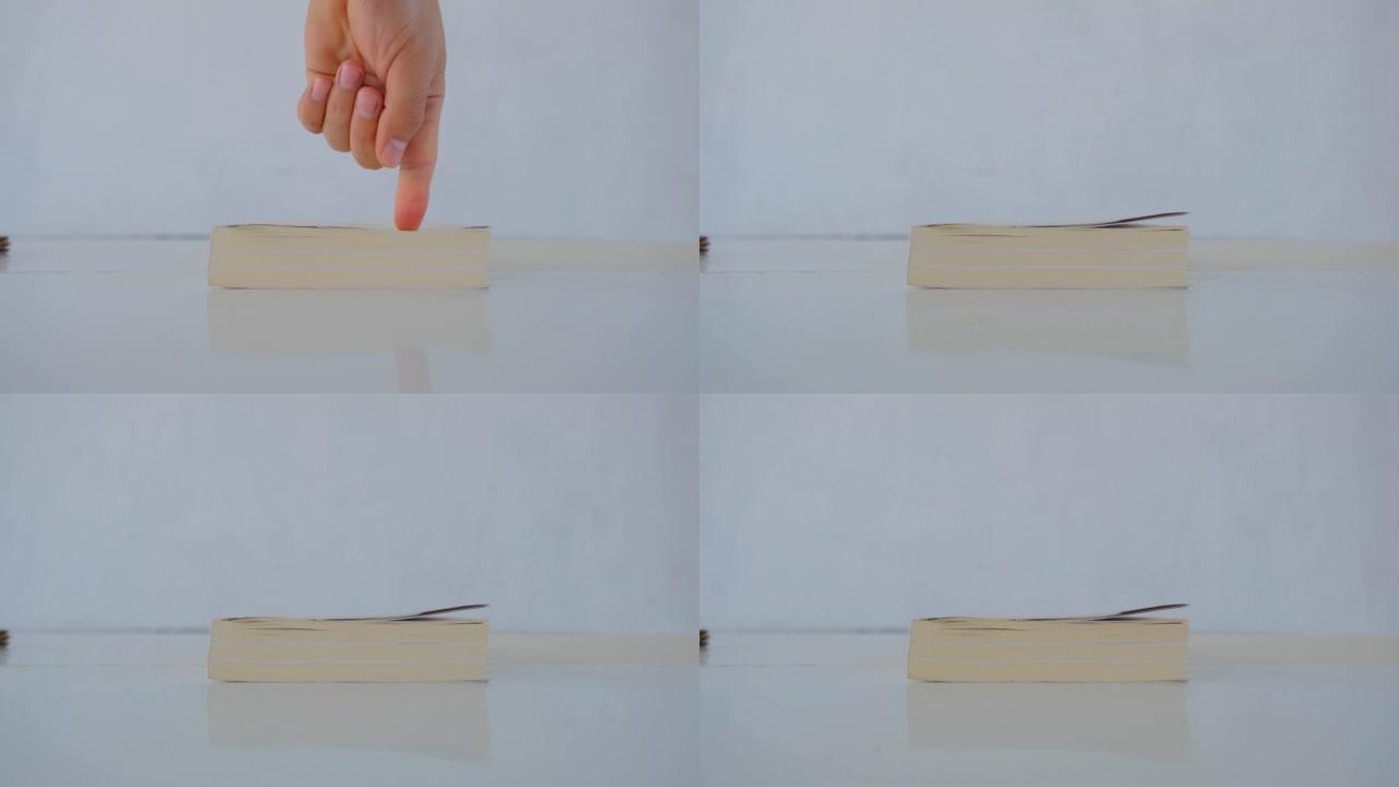 4k视频。人的手和手指显示一本书
